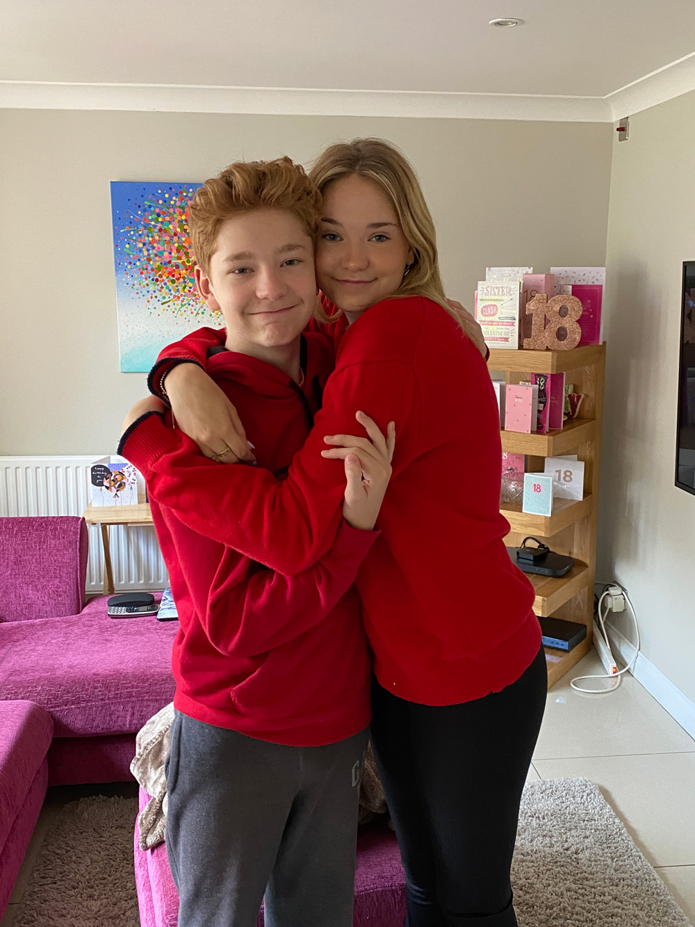 Siblings wearing red, hugging